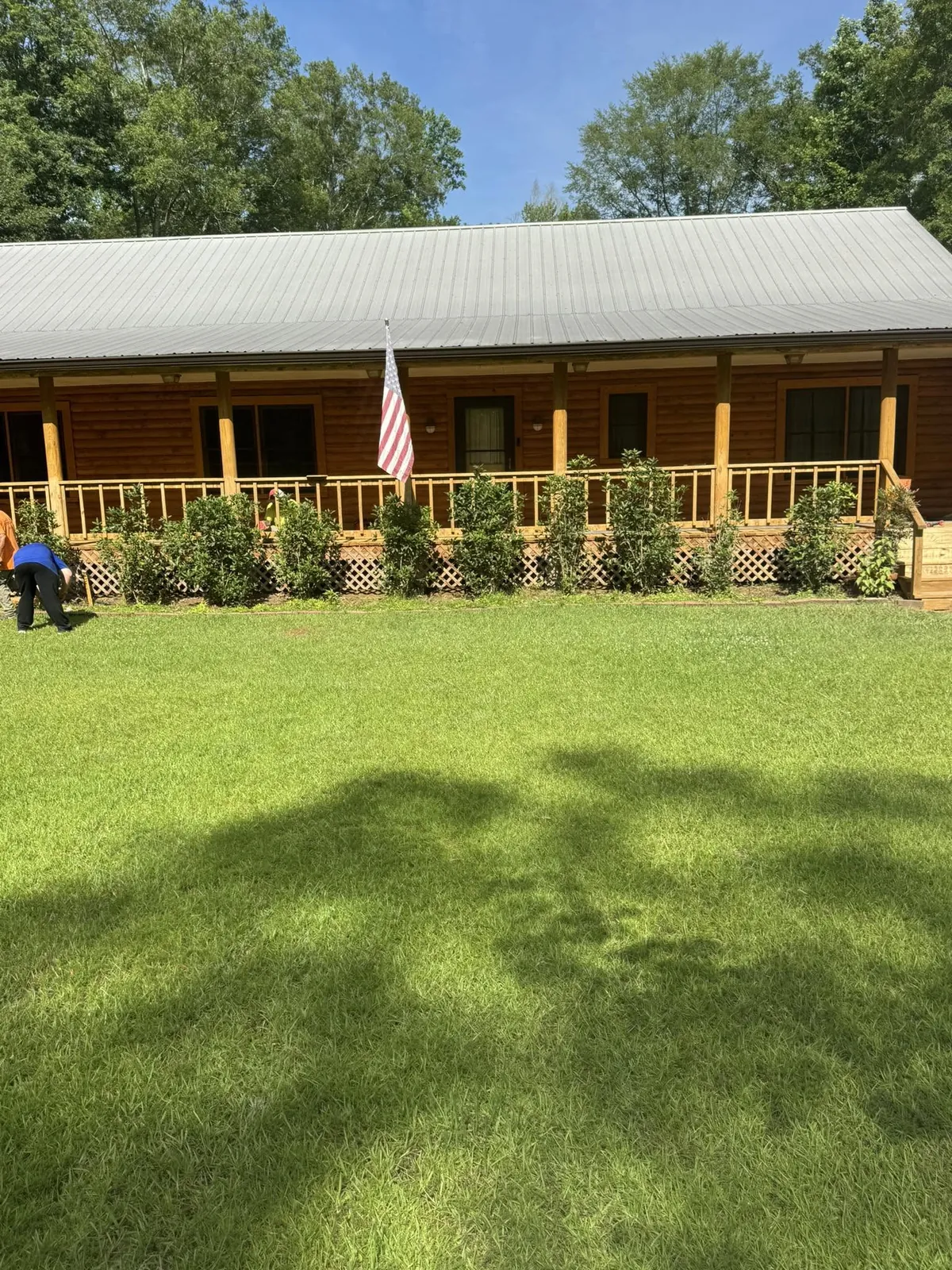 Log-style home with a covered front porch and trimmed lawn